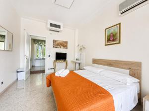 a bedroom with a large bed with an orange blanket at Oasi Venus Perugia e Assisi in Ponte San Giovanni
