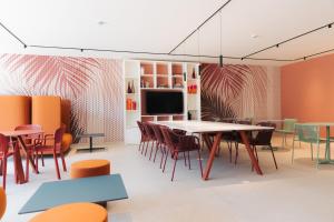 a dining room with tables and chairs and a tv at PALAZZO RUBINO Aparthotel in Olbia