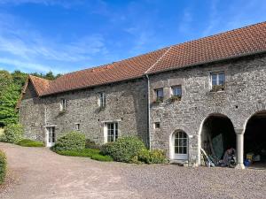an old stone building with windows and a roof at Le Manoir du Butel in Saint-Amand