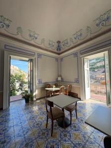 a room with a table and chairs on a tile floor at I Tetti di Siciliando in Modica