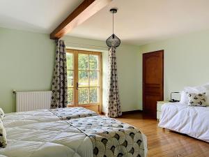 a bedroom with a bed and a window at Le Manoir du Butel in Saint-Amand