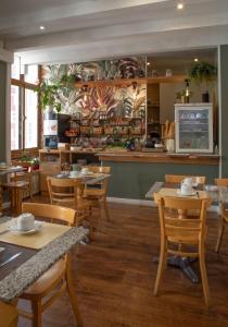 a restaurant with tables and chairs and a kitchen at Hôtel du Nord in Annecy