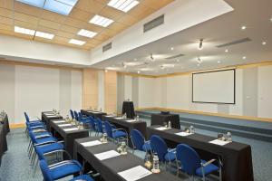 a conference room with tables and blue chairs and a screen at SOL by Meliá Port Cambrils in Cambrils +79 photos