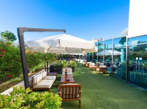 a row of tables and chairs with an umbrella at SOL by Meliá Port Cambrils in Cambrils
