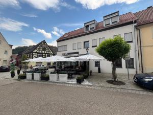 a building with tables and umbrellas in front of it at Edi`s Ferienwohnung in Eltmann