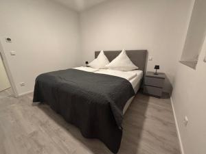a bedroom with a bed with a black blanket and white pillows at Edi`s Ferienwohnung in Eltmann