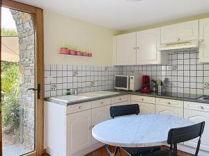 a small kitchen with a table and a microwave at Le Manoir du Butel in Saint-Amand