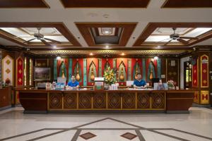 two people sitting at a counter in a lobby at Le Palace hotel krabi in Ban Khlong Haeng
