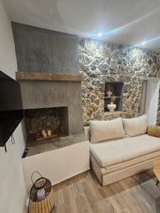 a living room with a couch and a stone fireplace at Stay In Zia in Asfendioú