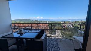 a balcony with a table and chairs and a view at Cozy apartment with exceptional view in Gex