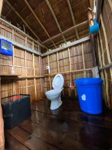 a bathroom with a toilet and a blue trash can at Sunrise Raja Ampat in Besir