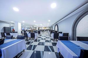 a restaurant with a checkered floor and tables and chairs at Elysium Elite Hotel in Kızılot