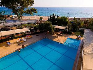 an overhead view of a large swimming pool next to the ocean at Elysium Elite Hotel in Kızılot +8 photos