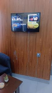 a flat screen tv hanging on a wooden wall at Assala Hotel in Faisalabad