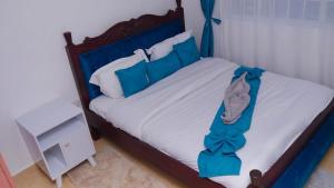 a bedroom with a bed with blue decorations on it at SJ Homes II in Eldoret