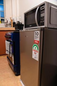 a microwave on top of a refrigerator in a kitchen at SJ Homes II in Eldoret