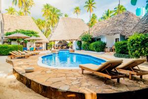 a resort with a pool and chairs and palm trees at Sea View Lodge Boutique Hotel in Jambiani