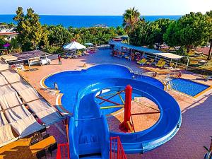 a large swimming pool with a blue water slide at Elysium Elite Hotel in Kızılot