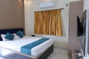 a bedroom with a bed with blue pillows and a window at Hotel RK Royale in Patna