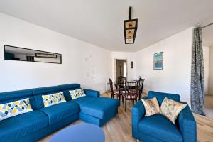 a living room with a blue couch and chairs at Le Delezir - Wifi - Balcon - Plage in Saint-Nazaire