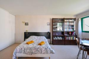 a bedroom with a bed and a book shelf at Le Delezir - Wifi - Balcon - Plage in Saint-Nazaire +10 photos