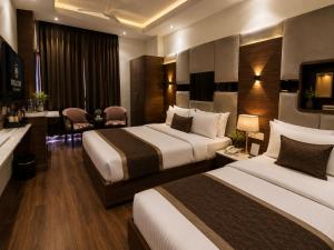 a hotel room with two beds and a television at Comfort Sure in Amritsar