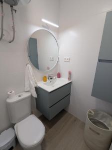 a bathroom with a toilet and a sink and a mirror at Apartamento luminoso in Mazarrón