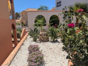 a garden in front of a house with flowers at Apartamento luminoso in Mazarrón