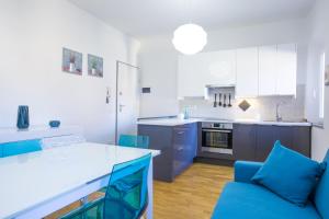une cuisine avec des placards bleus et un canapé bleu dans l'établissement Nila Apartment, à Porto Azzurro