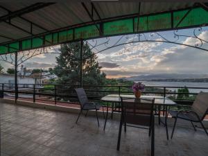 a table and chairs on a balcony with a view of the water at Beutiful view Cosy House with Starlink internet in Salamina