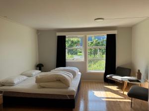 two beds in a room with two windows at Villa Fresvik in Fresvik