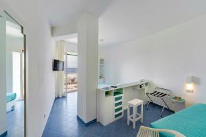 a room with a bed and a desk and a table at Hotel Baia Di Puolo in Massa Lubrense