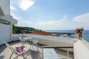 a balcony with chairs and a table and the ocean at Hotel Baia Di Puolo in Massa Lubrense