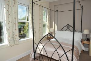 a bedroom with a black canopy bed with windows at Abbey Guest House York in York