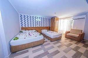 a room with two beds and a chair in it at Elysium Elite Hotel in Kızılot