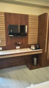 a room with a counter with a tv on a wall at Asusss International in New Digha