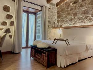 a bedroom with a white bed and a table at La Pelusa casa rural in La Culata