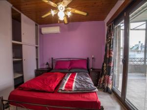 a bedroom with a red bed with a ceiling fan at Beutiful view Cosy House with Starlink internet in Salamina