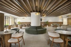 a restaurant with tables and chairs and a large ceiling at Pyramisa Suites Hotel Cairo in Cairo