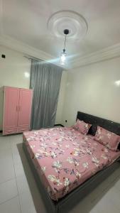 a bedroom with a pink bed with a pink blanket at Appartement confort keur massar in Rufisque