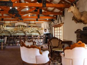 a room with chairs and a bar in a restaurant at Swartklip Game Lodge in Riversdale