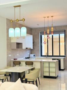 a kitchen with a table and chairs and chandeliers at Zabibu Residence in Nkongontha +6 photos