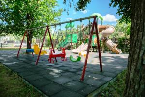 a playground with a bunch of swings in a park at Curtea Domneasca in Vaslui