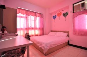 um quarto rosa com uma cama e um lavatório em Love Fengchia em Taichung