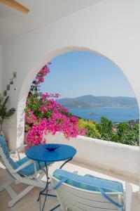 a balcony with a table and chairs and flowers at ILIOS COVE by A&D Properties in Porto Rafti +86 photos