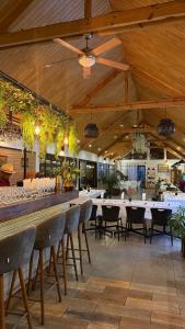 a restaurant with tables and chairs and a bar at Au Mirandav Hotel in Ambohidratrimo