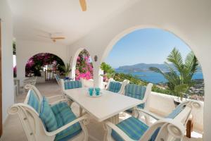 a white table and chairs with a view of the ocean at ILIOS COVE by A&D Properties in Porto Rafti
