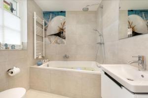 a bathroom with a tub and a sink and a toilet at Ferienhäuser TraumZeit in Zingst