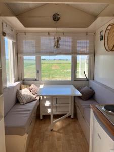 a table and couch in a tiny house at Strandelijk plekje in Nieuwerkerk