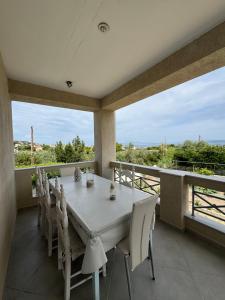 a dining room with a table and chairs on a balcony at For a good hospitality in Souvala